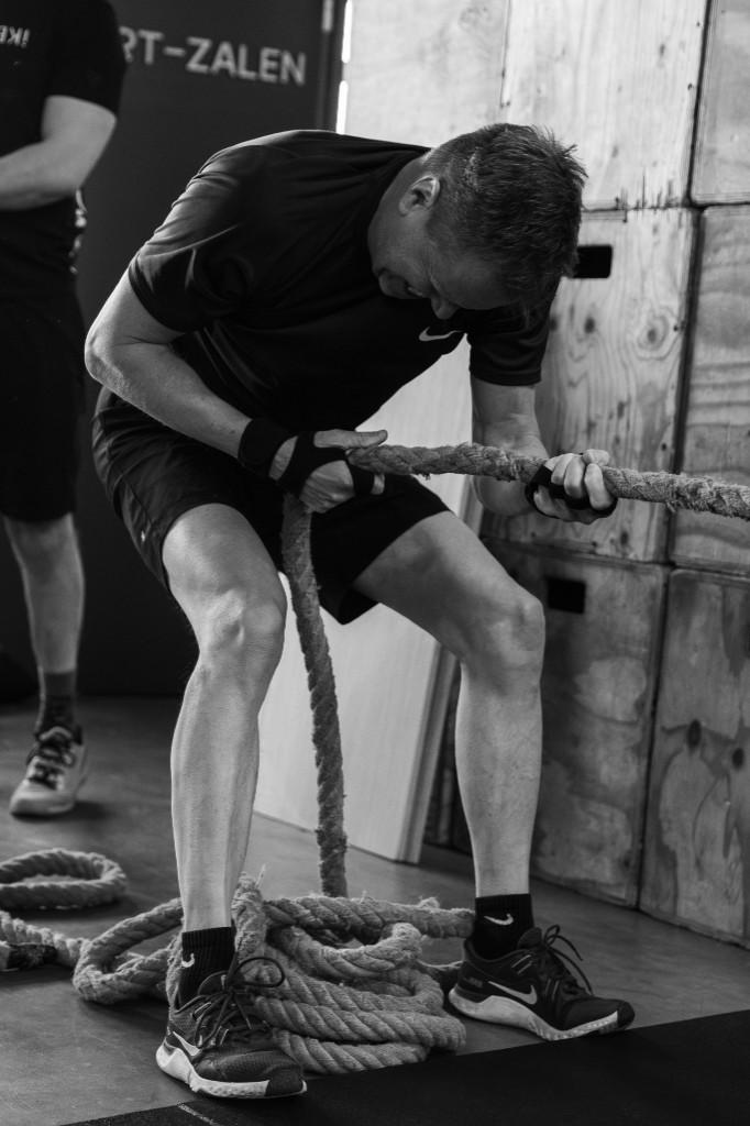Team in actie: battle ropes tijdens training bij STARK! Hardenberg, zwart-wit, kracht en samenwerking