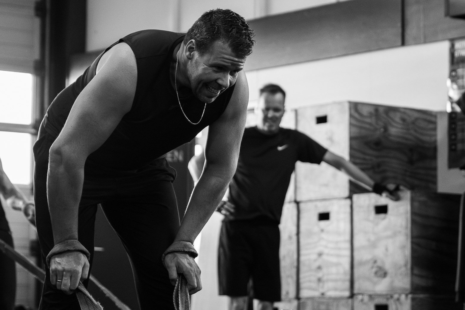 Deelnemer trekt een sled bij STARK! Hardenberg, met een coach op de achtergrond